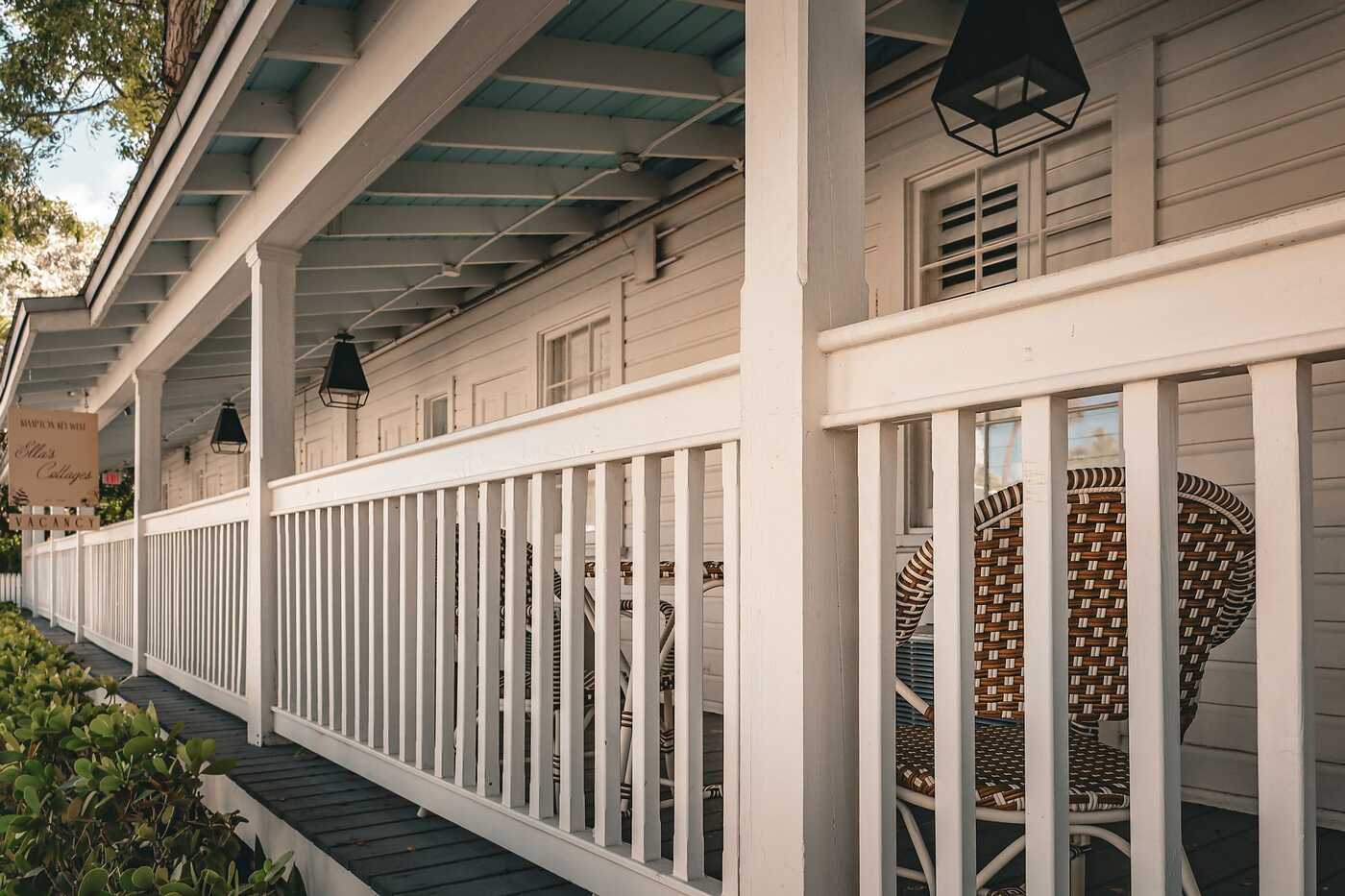 A porch with wicker chairs and white railings