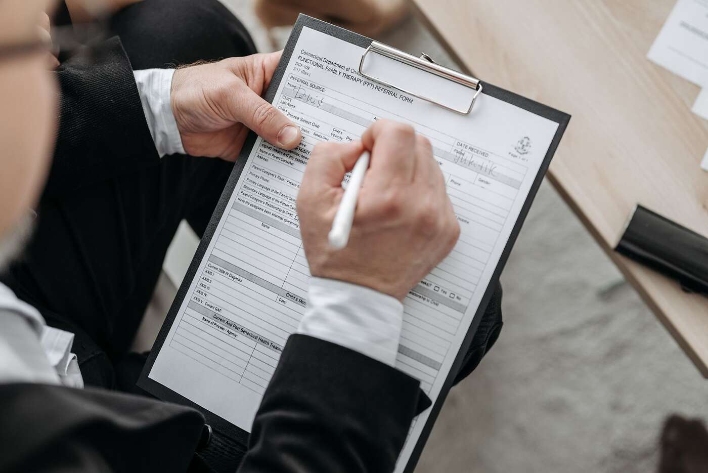 A hand signing a document on a clipboard