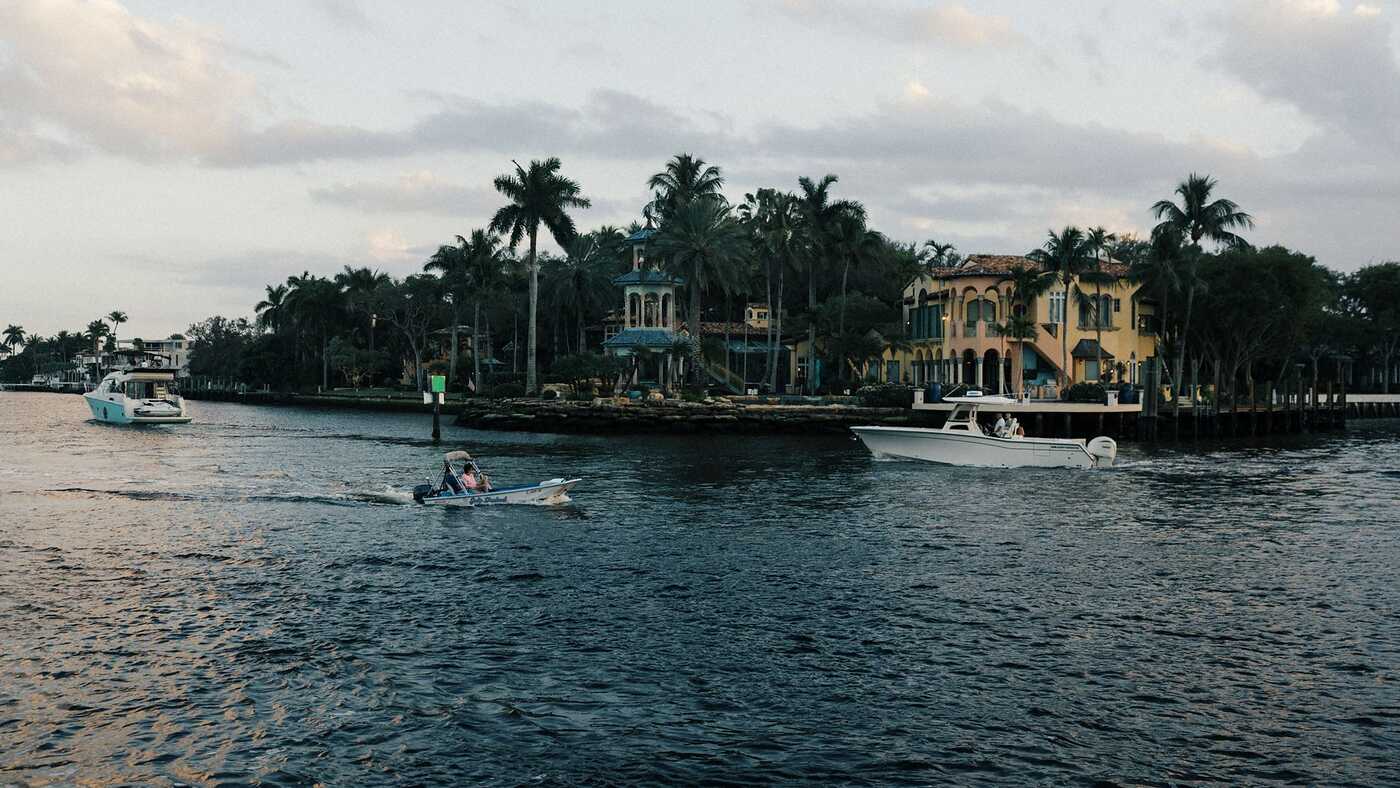 A boat passing waterfront homes on a calm waterway