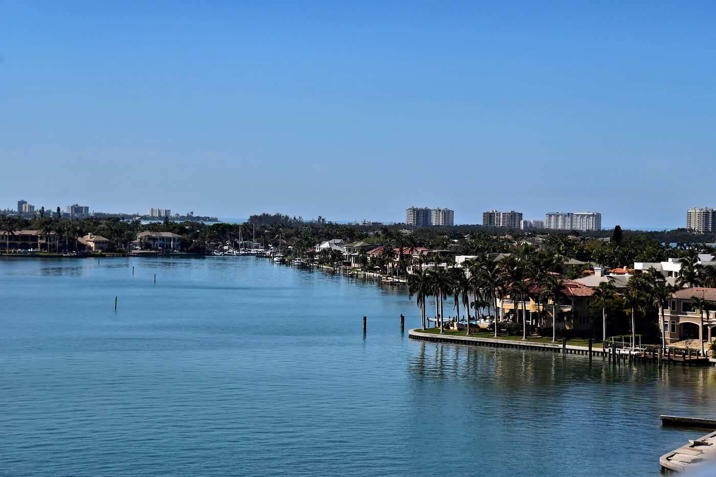 A Florida waterfront of houses and calm water under a clear sky