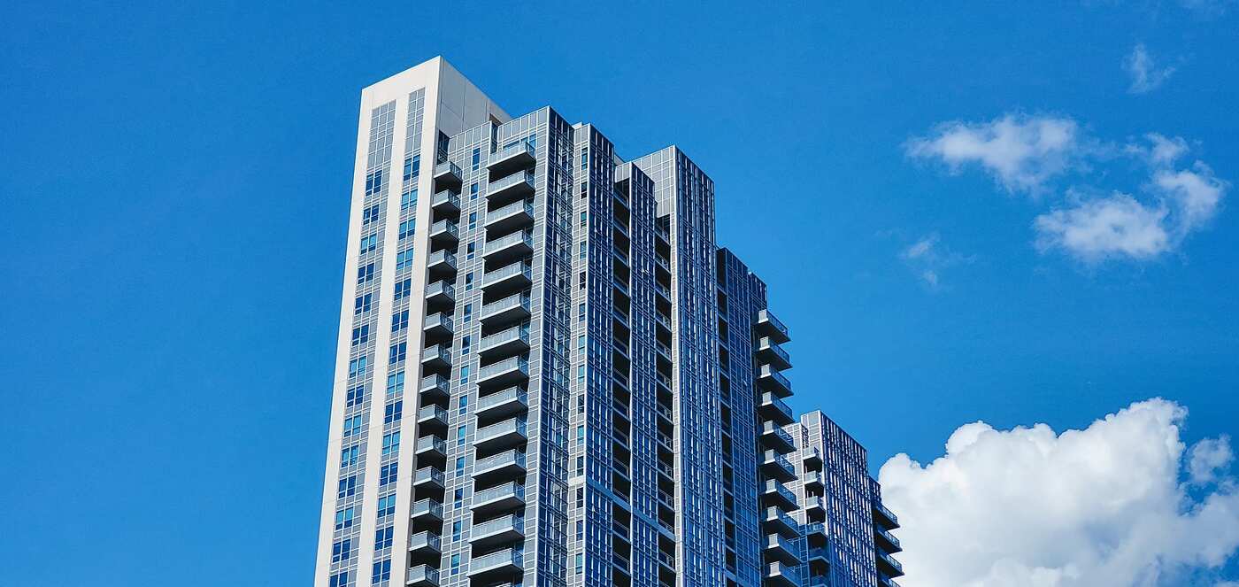 A modern high-rise with balconies against a clear sky